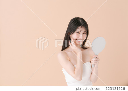 A woman smiling with a hand mirror 123121626