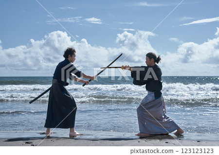 Two kendo practitioners practicing on the beach 123123123