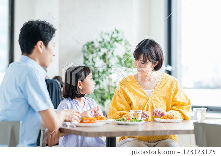A family eating a meal at a restaurant. 123123175