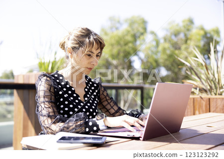 A woman using a laptop in the park A woman using a laptop in the park 123123292