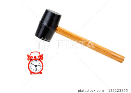 The rubber hammer is about to smash the red tiny alarm clock. 123123855