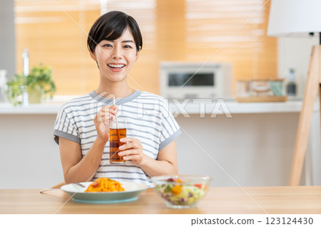 A woman eating lunch in the living room. 123124430