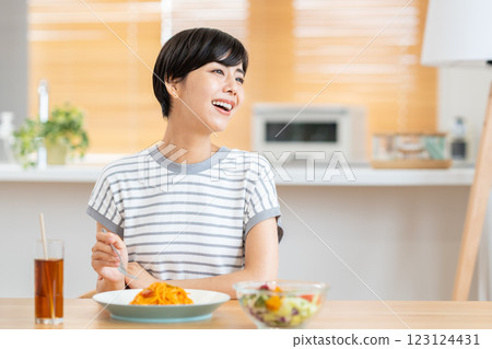 A woman eating lunch in the living room. 123124431
