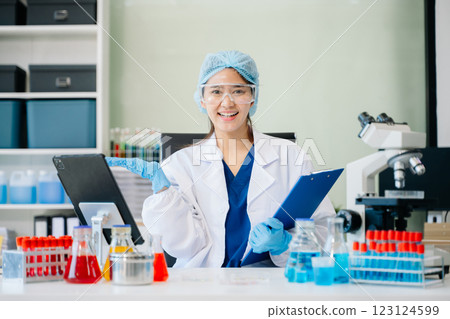 female scientist working with micro pipettes analyzing biochemical 123124599