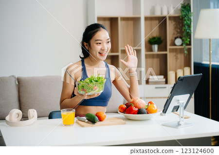 Woman enjoys a fresh salad with fruits and juice, embodying wellness, nutrition, and vitality 123124600