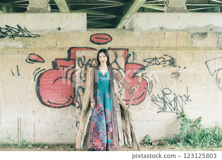 一名女子在天橋下的塗鴉前擺姿勢 123125803