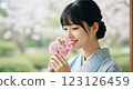一個女人享受著花香 123126459
