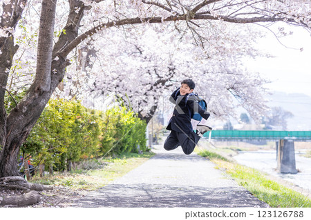 Junior high school students jumping under the cherry blossom trees Junior high school students jumping under the cherry blossom trees 123126788