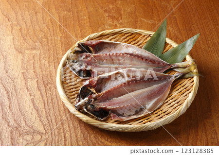 Two filleted horse mackerel served in a colander on a wood grain background Two filleted horse mackerel served in a colander on a wood grain background 123128385