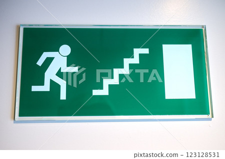 Green emergency sign indicate the right direction hanging 123128531