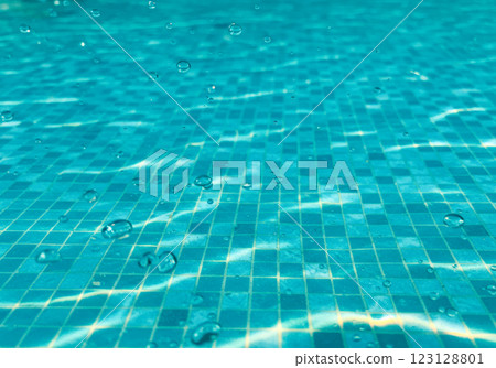 A blue tiled swimming pool floor with sunlight reflecting off the water (AI-generated image) 123128801