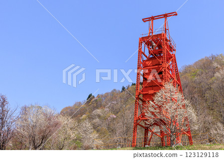 A shaft hoisting machine stands tall in the Coal Mine Memorial Forest Park, where kobushi trees bloom, in Bibai City, Hokkaido [May] 123129118
