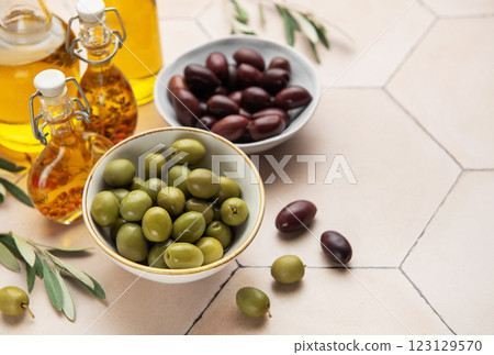 Bowls of green and black olives with olive oil bottles and olive branches Bowls of green and black olives with olive oil bottles and olive branches 123129570