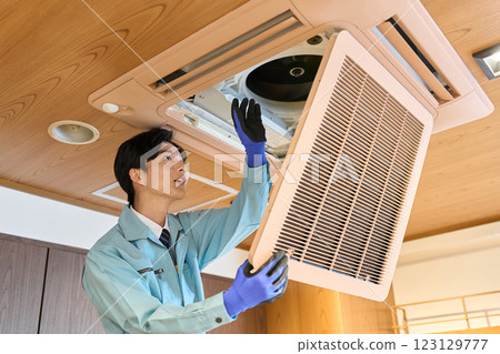 A man checking the air conditioning equipment in a restaurant A man checking the air conditioning equipment in a restaurant 123129777