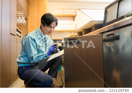 A man checking a restaurant's refrigerator 123129784