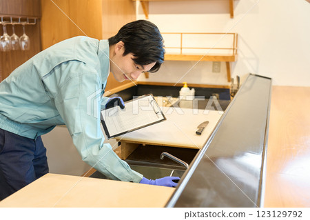 A man checking the water supply at a restaurant 123129792