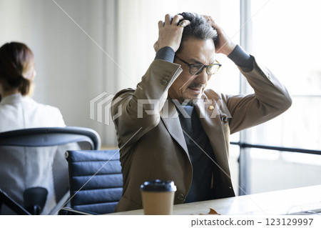 Middle-aged man working in the office Middle-aged man working in the office 123129997