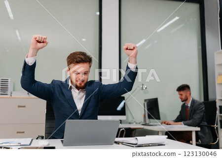 Excited Young Businessman Celebrating Success in Modern Office. Excited Young Businessman Celebrating Success in Modern Office. 123130046
