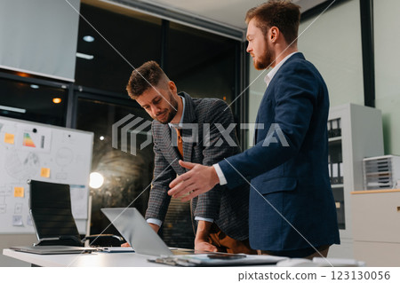 Diverse professionals collaborate on project analysis with financial graphs. Diverse professionals collaborate on project analysis with financial graphs. 123130056