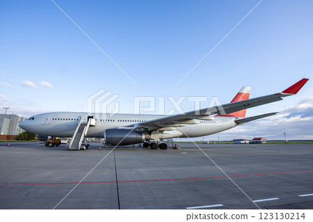 Wide body passenger jet plane with boarding stairs at the airport Wide body passenger jet plane with boarding stairs at the airport 123130214