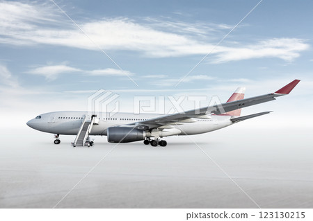 Wide body passenger airplane with boarding stairs on bright background with sky Wide body passenger airplane with boarding stairs on bright background with sky 123130215