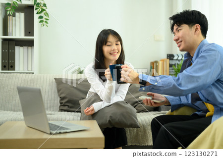Smiling couple toasting with coffee mugs and enjoying a casual break at home Smiling couple toasting with coffee mugs and enjoying a casual break at home 123130271