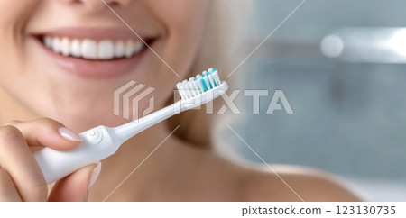 Beautiful woman toothbrush in hand, bathroom setting, electric device, smiling face, personal hygiene, dental care, grooming focus, clean lifestyle, oral health, wellness routine, radiant expression. Beautiful woman toothbrush in hand, bathroom setting, electric device, smiling face, personal hygiene, dental care, grooming focus, clean lifestyle, oral health, wellness routine, radiant expression. 123130735