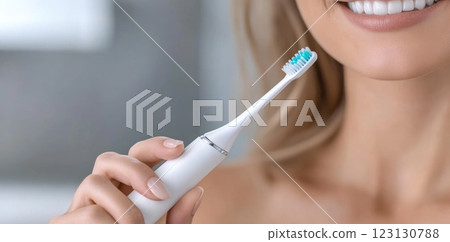 Beautiful woman toothbrush in hand, bathroom setting, electric device, smiling face, personal hygiene, dental care, grooming focus, clean lifestyle, oral health, wellness routine, radiant expression. 123130788