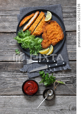 Pork Milanese with lettuce and lemon on a plate Pork Milanese with lettuce and lemon on a plate 123131156