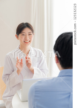 A woman at the reception desk wearing a white coat A woman at the reception desk wearing a white coat 123132123
