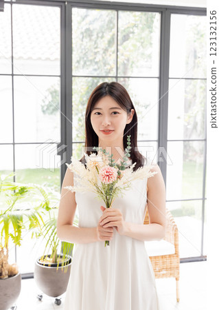One-piece woman holding a bouquet of dried flowers One-piece woman holding a bouquet of dried flowers 123132156
