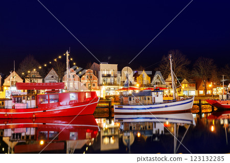 Traditional old german fishing boats cafe moored Alter Strom Canal Warnemunde harbor fishing market Northern Germany. Commercial fish crab shrimp trawler beam trawl nets  small port city 123132285