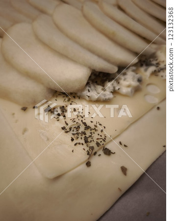 Gourmet pastry layering delicate cheese, ripe pear slices, and fresh herbs, revealing intricate culinary craftsmanship easy dinner for Valentines day 123132368