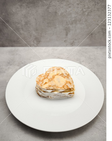 Heart shaped crepes cake layering white yogurt, sitting on white plate, symbolizing romantic love and culinary artistry for Mother's Day Valentines copy space Heart shaped crepes cake layering white yogurt, sitting on white plate, symbolizing romantic love and culinary artistry for Mother's Day Valentines copy space 123132377