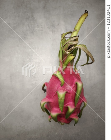 Ripe dragon fruit resting on a textured gray surface in prague 123132411