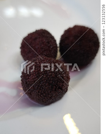 Three ripe red bayberries resting on white plate all you can eat Three ripe red bayberries resting on white plate all you can eat 123132556