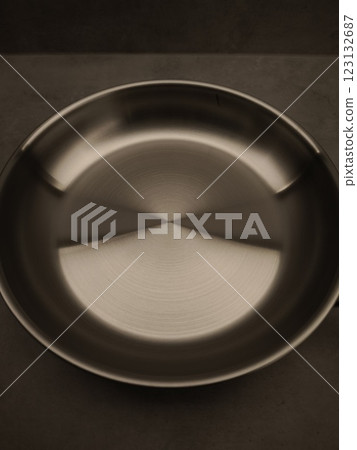 Stainless steel frying pan is waiting on a kitchen countertop, ready to be used for cooking, close up Stainless steel frying pan is waiting on a kitchen countertop, ready to be used for cooking, close up 123132687