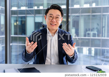 Confident Asian Businessman Explaining Ideas During Professional Office Meeting Confident Asian Businessman Explaining Ideas During Professional Office Meeting 123132939