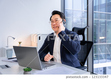 Professional Businessman Talking on Smartphone in Modern Office Setting Professional Businessman Talking on Smartphone in Modern Office Setting 123133347