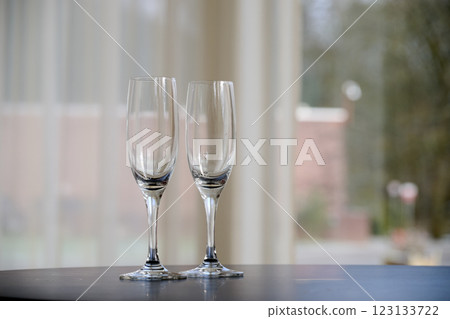 Two empty glasses of Champagne on table after party Two empty glasses of Champagne on table after party 123133722