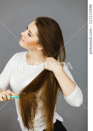 Happy woman brushing her hair 123133896