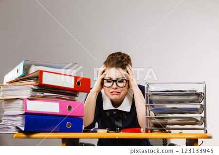 Depressed businesswoman sitting at desk Depressed businesswoman sitting at desk 123133945