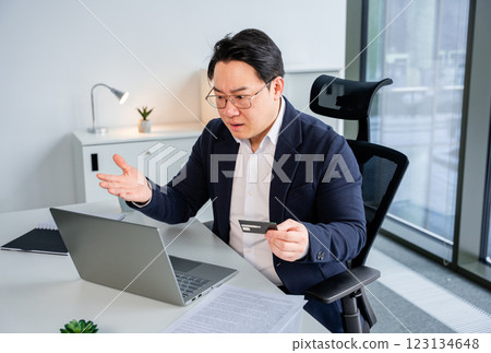 Professional Businessman Using Laptop and Credit Card in Modern Office 123134648