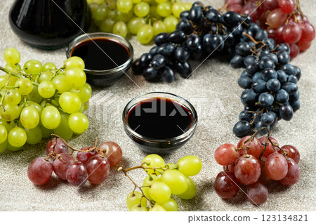 Balsamic vinegar poured into a glass sauce dish among the grapes 123134821