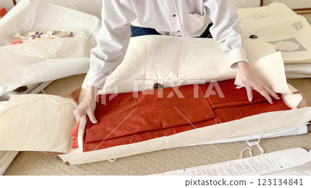 一位女士的手在折疊紙上折疊一件傲慢的紙和服 123134841