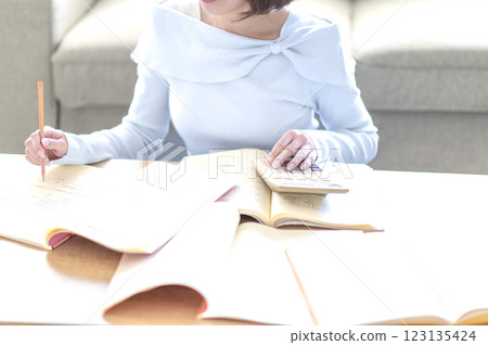 一位年輕女子獨自在客廳學習 123135424