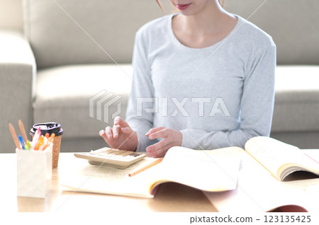 一位年輕女子獨自在客廳學習 123135425