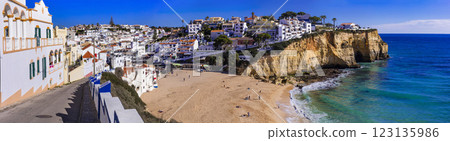 Portugal, beauiful  sunny Algarve coast. Panorama of scenic coastal town Carvoeiro with nice golden beach and white houses 123135986
