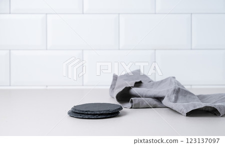 Kitchen countertop with black slate stands and napkin on white brick background. 123137097