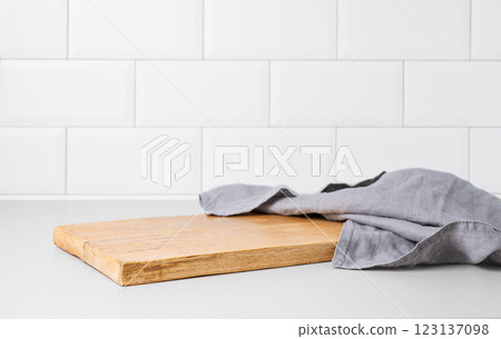 Kitchen countertop with cutting board and napkin on white brick background. 123137098